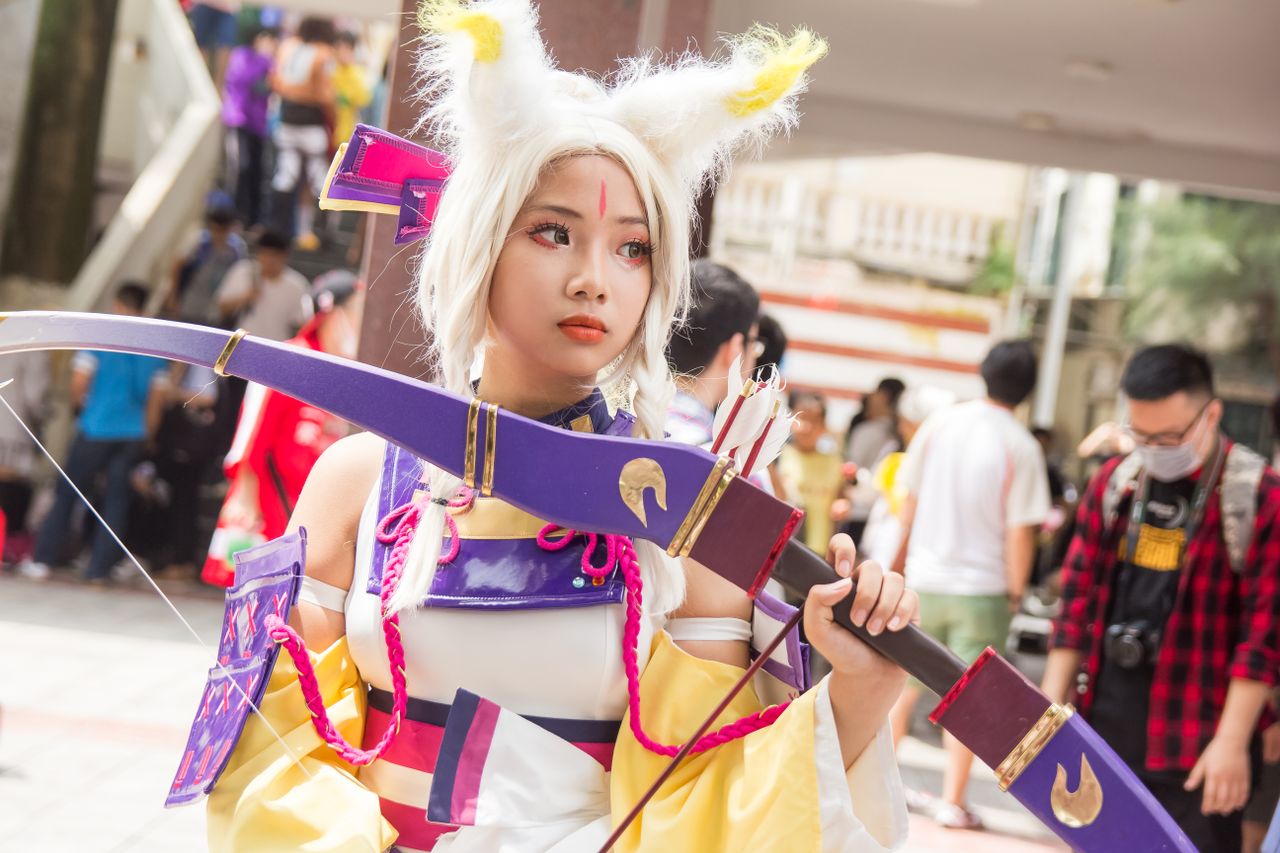 About A vibrant cosplay costume showcased by a young adult at an outdoor anime festival, capturing the essence of fun.