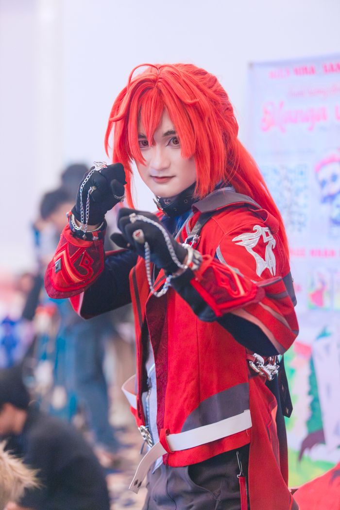 Menus Vibrant cosplay character with red hair and outfit posing at a convention.