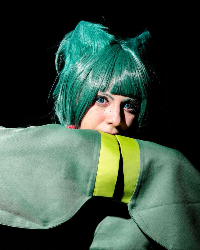 Home Dynamic cosplay portrait showcasing a vibrant green-haired character with unique styling.