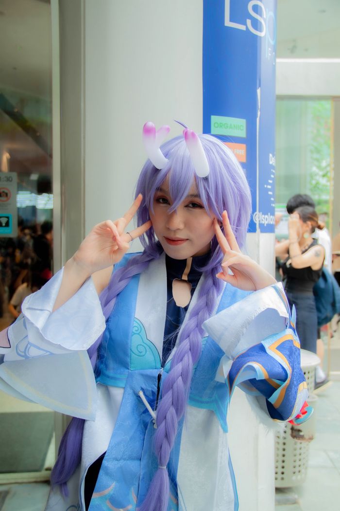 Menus Cosplayer in a vibrant anime costume posing at a lively convention.